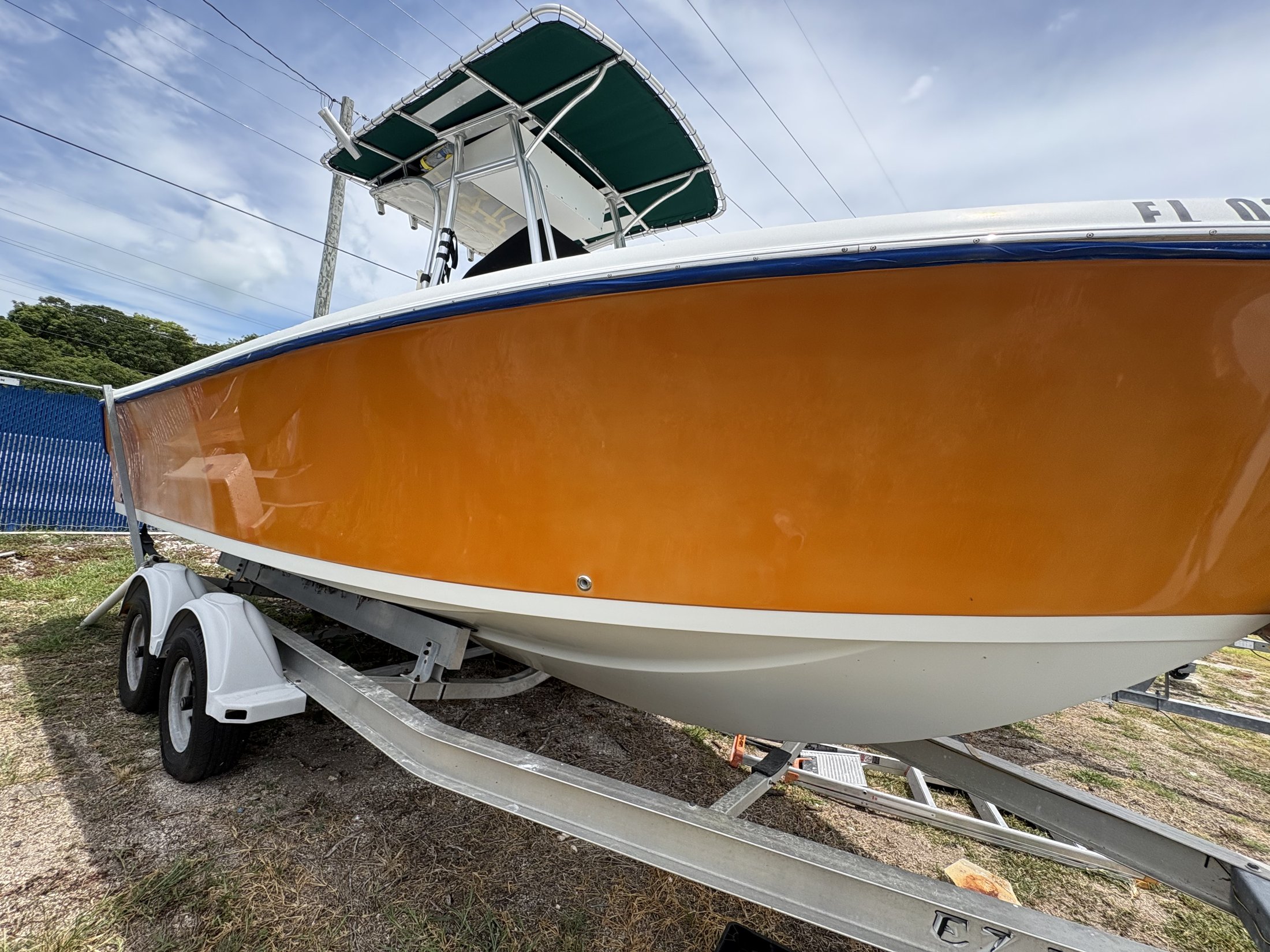 Orange-hulled boat during exterior finish care