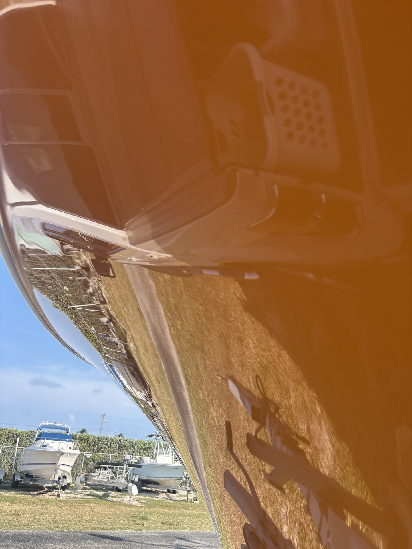 Close-up of a glossy orange center-console hull after gelcoat correction